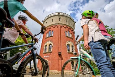 Familie mit Fahrrädern im Sommer vor der Camera Obscura Mülheim