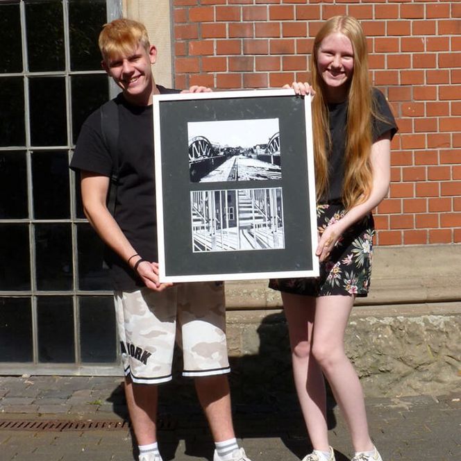 Schüler und Schülerin der Realschule Broich mit einem Bild ihrer Ausstellung „Strukturen” 2022 in der Camera Obscura